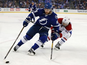Nikita Nesterov of the Tampa Bay Lightning tries to avoid a check by Mark Barberio of the Montreal Canadiens during the second period at Amalie Arena on Dec. 28, 2016 in Tampa. (Mike Carlson/Getty Images)