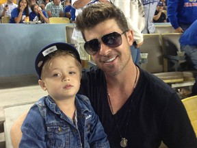 In this handout photo provided by the Los Angeles Dodgers, Robin Thicke (R) poses for a photo with son Julian Fuego Thicke at the New York Mets v Los Angeles Dodgers game at Dodger Stadium on August 14, 2013 in Los Angeles, California. (Photo by Los Angeles Dodgers via Getty Images)