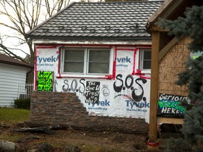 Allison Stacey plastered her Boler Road home with signs to draw attention to a contractor she accuses of not finishing renovations. Stacey moved the signs from her front lawn after the city?s bylaw office ordered them removed. (MIKE HENSEN, The London Free Press)