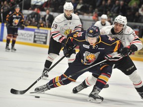 BARRIE - Owen Sound Attack defenseman Sean Durzi (right) tries to slowdown the Barrie Colts Zach Magwood during first period Ontario Hockey League action on Thursday.