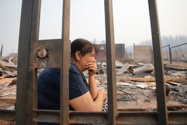 A woman sits on remains of a home destroyed by fire in Santa Olga, Chile, Thursday, Jan. 26, 2017. Chilean officials say that the town of Santa Olga was consumed in the flames of the country's worst wildfires, but its 6,000 residents escaped unharmed. The flames engulfed the post office, a kindergarten, and hundreds of homes Thursday in the town located 220 miles (360 kilometers) south of the Chilean capital. (Javier Torres/Aton via AP)