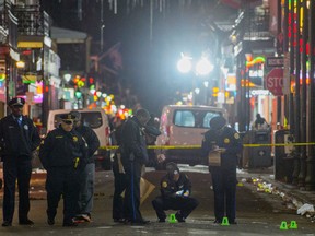 In this Nov. 27, 2016 file photo, New Orleans Police Department investigators study a crime scene after a fatal shooting in New Orleans. (Matthew Hinton /The Advocate via AP, File)