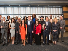 This image released by NBC shows the cast of "The New Celebrity Apprentice," back row from left, Matt Iseman, Laila Ali, Ricky Williams, Porsha Williams, Lisa Leslie, Boy George, Eric Dickerson, Chael Sonnen, and front row from left, Nicole Polizzi, Carson Kressley, Brooke Burke, Vince Neil, Kyle Richards, Arnold Schwarzenegger, Carnie Wilson, Jon Lovitz and Carrie Keagan in Los Angeles. (Luis Trinh/NBC via AP)