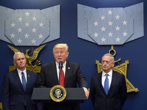 U.S. President Donald Trump, centre, flanked by U.S. Vice President Mike Pence, left, and U.S. Defense Secretary James Mattis, right, speaks during an event at the Pentagon in Washington, Friday, Jan. 27, 2017. (AP Photo/Susan Walsh)