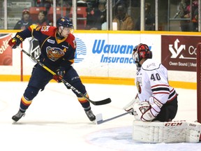 Erie Otters' Kyle Pettit, left, chips a power play goal past the Owen Sound Attack's goalie Michael McNiven during Ontario Hockey League first period action at the Lumley Bayshore in Owen Sound, Ont. on Saturday, December 3, 2016. (Postmedia News file photo)