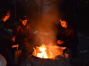Damon Strong, left, Nathan Tomaz and Austin Struthers, of Ayr, enjoy an outdoor fire at their yurt site in Windy Lake Provincial Park. (Jim Moodie/Sudbury Star)