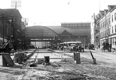 Looking west along Front St. E. towards Jarvis St. in November 1921. In the foreground, crews of the newly created Toronto Transportation (after 1954 Transit) Commission prepare a new road bed for the streetcar tracks that would replace those that had been in use for decades, primarily by the wooden streetcars built and subsequently repaired at the nearby shops of the TTC’s privately owned predecessor, the Toronto Railway Company. In the background is the steel canopy of the covered pedestrian walkway over Front St. that connected the North and South St. Lawrence Markets. It was erected many years after the South market was officially opened on Oct. 4, 1902. Deemed unsafe in the early 1950s, the glass was finally removed in 1952 (after several pieces fell) and the steelwork taken down a year later.