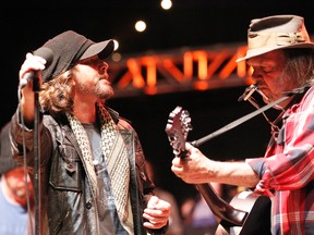 In this Oct. 24, 2010, file photo, Eddie Vedder, left of Pearl Jam performs with Neil Young, right, during the Bridge School Benefit concert in Mountain View, Calif. (AP Photo/Tony Avelar, File)