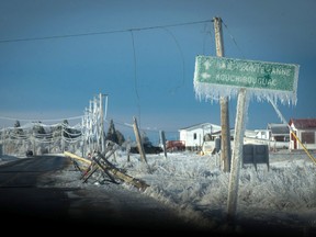 Downed power poles and ice covered signs are shown in Escuminac, N.B., on Friday, Jan. 27, 2017. (THE CANADIAN PRESS/Diane Doiron)
