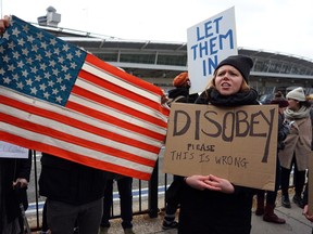 Protesters assemble at John F. Kennedy International Airport in New York, Saturday, Jan. 28, 2017 after two Iraqi refugees were detained while trying to enter the country. (AP Photo/Craig Ruttle)