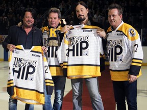 Paul Langlois, Gord Sinclair and Rob Baker of The Tragically Hip receive custom jerseys from Frontenacs' general manager Doug Gilmour before the ceremonial puck-drop at the Kingston Frontenacs game versus Mississauga last month. (Steph Crosier/The Whig-Standard)