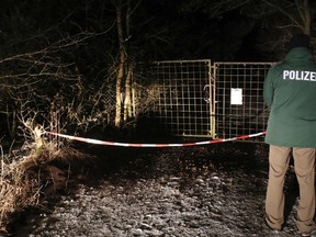 A police officer stands in front of a closed off entrance to a private ground near Arnstein, Germany, Sunday Jan. 29, 2017. (Daniel Karmann/dpa via AP)