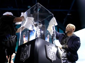 Workers prepare the Vince Lombardi Trophy display at the NFL Experience in Houston on Saturday, Jan. 28, 2017. The Patriots will play the Falcons in Super Bowl LI at NRG Stadium in Houston on Sunday, Feb. 5, 2017. (David J. Phillip/AP Photo)