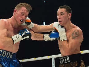Ajax, Ont.’s Brandon Cook (left) and Quebec rival Steven Butler trade punches during their IBF/WBA light middleweight boxing match in Montreal on Saturday. Cook won by TKO in the seventh round in front of the hostile crowd. (The Canadian Press)