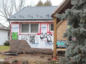 Allison Stacey plastered her Boler Road home with signs to draw attention to a contractor she accuses of not finishing renovations. Stacey moved the signs from her front lawn after the city's bylaw office ordered them removed. (DALE CARRUTHERS / THE LONDON )