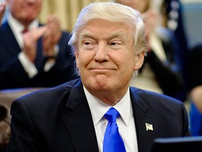 U.S. President Donald Trump signs three executive actions in the Oval Office on Jan. 28, 2017 in Washington, D.C. (Photo by Pete Marovich - Pool/Getty Images)