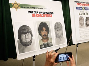 A reporter take photos of posters showing images of a suspect in the 1976 murder of Karen Klaas, ex-wife of the Righteous Brothers singer Bill Medley, at a news conference, Monday, Jan. 30, 2017, in Los Angeles.  (AP Photo/Jae C. Hong)