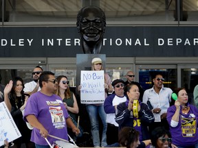 Demonstrators chant outside Tom Bradley International Terminal during a protest by airport service workers from United Service Workers West union Monday, Jan. 30, 2017, at Los Angeles International Airport. The vigil in support of travelers affected by the executive order restricting travel from seven primarily Muslim countries. (AP Photo/Chris Carlson)