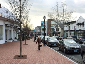 In this Thursday, Jan. 26, 2017 photo, a woman walks near shops in downtown Westport, Conn. A town-sponsored essay contest on the topic of white privilege has stirred controversy in the affluent, overwhelmingly white town on Connecticut's shoreline. (AP Photo/Michael Melia)