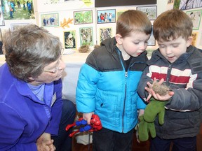 Leslie Anne Sheldon lets Jaden Marks and Corbin Berry examine a small bird nest at the Woodstock Field Naturalists Club booth during the Woodstock Recreation and Leisure Fair a couple of years ago. (Sentinel-Review file photo)