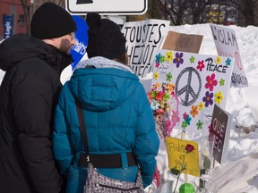 A couple stands in front of a makeshift memorial near the site of the mosque shooting, Tuesday, January 31, 2017 in Quebec City. (THE CANADIAN PRESS/Jacques Boissinot)