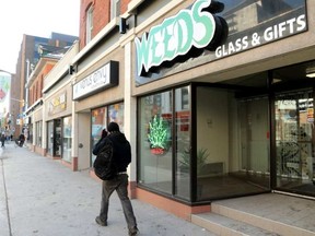 Weeds Glass and Gifts’s pot sign was lit up, but police were inside on the Bank Street store Tuesday afternoon. JULIE OLIVER / POSTMEDIA