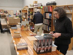 Joanne Sparks, right, looks through a newly arrived box of books donated to the volunteer committee of the Kingston Symphony Association's warehouse. Books, records and miscellaneous items are resold to benefit the Kingston Symphony. (Michael Lea/The Whig-Standard)