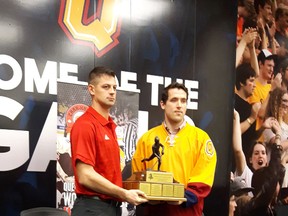 RMC captain Eric Bouchard  (left) and Queen's captain Patrick Downie with the Carr-Harris Cup Challenge trophy.  (Doug Graham/Postmedia Network)