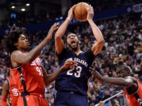 New Orleans Pelicans forward Anthony Davis is fouled by Toronto Raptors forward Pascal Siakam as centre Lucas Nogueira defends during an NBA game in Toronto on Jan. 31, 2017. (THE CANADIAN PRESS/Nathan Denette)