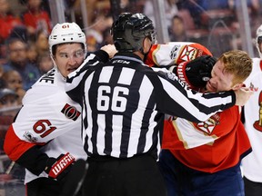 A referee gets in between Mark Stone (left) and Panthers defenceman Michael Matheson on Tuesday night in Sunrise, Fla. (The Associated Press)