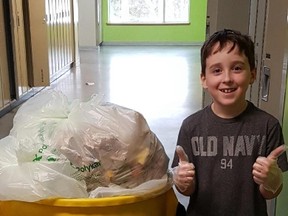 Grade 3 student Reece Keyes collects green bin waste at Walden Public School where a new composting program was launched recently. Supplied photo