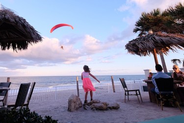 A young girl watches a para-glider scoot past at Mulligan's Beach Bar in Vero Beach, Florida. JIM BYERS PHOTO
