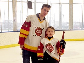 Denim Stark, 8, stands with Edmonton Oilers Captain Connor McDavid after a private skating session with 33 other youth from around the province. Submitted Photo.