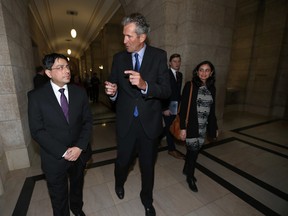 Manitoba Premier Biran Pallister talks with Narinder Pahwa (left) who, along with Divya Kaeley and son Parth, all became Canadian citizens at a swearing-in ceremony on Wednesday at the Manitoba Legislature. 
(Winnipeg Sun/Postmedia Network)
