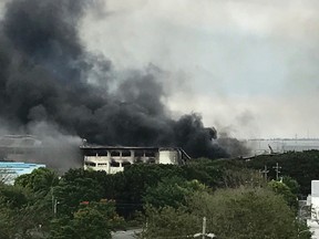 Smoke rises from a factory compound, Thursday, Feb. 2, 2017, in General Trias town in Cavite province, south of Manila, Philippines. The Cavite provincial governor says more than 100 workers, including three Japanese, have been injured and at least three are missing in a fire that hit a huge factory south of Manila and sent thousands of employees scampering to safety. (AP Photo/Joeal Calupitan)