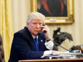 U.S. President Donald Trump speaks on the phone with Prime Minister of Australia Malcolm Turnbull in the Oval Office of the White House in Washington Jan. 28, 2017. (AP Photo/Alex Brandon)