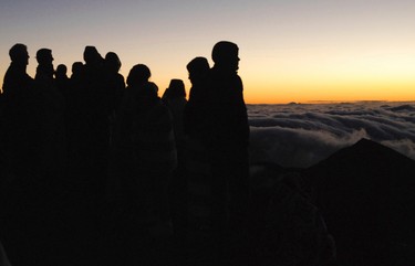 People gather ahead of the sunrise on the summit of Haleakala volcano in Haleakala National Park on Hawaii's island of Maui, Sunday, Jan. 22, 2017. Mark Twain called the daily phenomenon the “sublimest spectacle” he ever witnessed. (AP Photo/Caleb Jones)