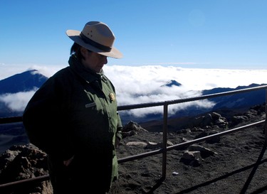 Polly Angelakis, Chief of Interpretation and Education at Haleakala National Park, stands on the summit of Haleakala volcano shortly after sunrise on Hawaii's island of Maui, Monday, Jan. 23, 2017. Under a new system, those driving to the summit between 3 and 7 a.m. need reservations, which cost $1.50 per car plus the $20 entrance fee for the park. The proceeds will pay for the expense of administering the reservation program. People on guided tours won’t be affected as tour companies fall under different regulations. (AP Photo/Caleb Jones)