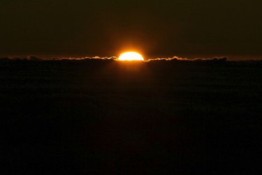 The sun rises in front of the summit of Haleakala volcano in Haleakala National Park on Hawaii's island of Maui, Sunday, Jan. 22, 2017. Park officials say the sunrise on Haleakala attracts over a thousand people a day, resulting in an overload of visitors and creating a safety hazard. As a result, anyone wanting to see the sunrise on the summit will now be required to make reservations in advance and pay a small fee. (AP Photo/Caleb Jones)