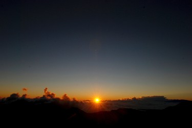 The sun rises in front of the summit of Haleakala volcano in Haleakala National Park on Hawaii's island of Maui, Tuesday, Jan. 24, 2017. Park officials say the sunrise on Haleakala attracts over a thousand people a day, resulting in an overload of visitors and creating a safety hazard. (AP Photo/Caleb Jones)