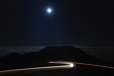 In this photo taken with a long exposure, cars drive up the access road to the summit of Haleakala volcano in Haleakala National Park hours before sunrise on Hawaii’s island of Maui, Sunday, Jan. 22, 2017. The long winding drive leads to the summit at 10,000 feet. (AP Photo/Caleb Jones)