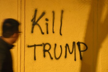 A man looks at graffiti during a protest in Berkeley, California on February 1, 2017. Violent protests erupted at the University of California at Berkeley over the scheduled appearance of a controversial editor of the conservative news website Breitbart. JOSH EDELSON/AFP/Getty Images