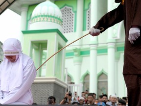 A 20-year old Muslim woman gets caned after being caught in close proximity with her boyfriend in Banda Aceh on Oct. 31, 2016. Aceh is the only province in the predominantly Muslim country that applies Sharia law, and public canings for breaches of Islamic code happen on a regular basis and often attract huge crowds. (GETTY IMAGES)