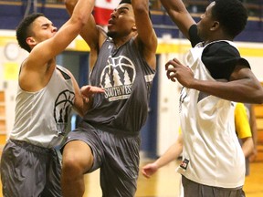 Xavier Ochu goes up for a shot while being guarded by Helgi Jacobsen and Josh Masella during a practice at Southwest Academy at Regina Mundi in London, Ont. on Thursday February 2, 2017. Mike Hensen/The London Free Press/Postmedia Network