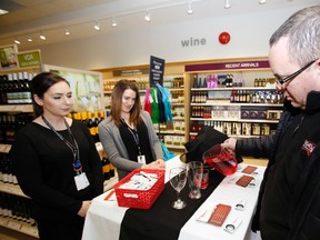 Luke Hendry/The Intelligencer
Jeff Brooks tries a health unit challenge to pour a standard-size drink at the Bell Boulevard LCBO store Thursday in Belleville. Watching were public health nurses Stephanie MacDonald, left, and Jenny Gaylord.