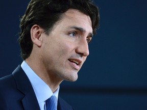 In a Tuesday, Nov. 29, 2016 file photo, Canada's Prime Minister Justin Trudeau holds a press conference at the National Press Theatre in Ottawa, Ontario. Canada's ethics commissioner is launching an investigation into Prime Minister Justin Trudeau's recent family holiday at the Aga Khan's private island in the Bahamas. Ethics commissioner Mary Dawson said Monday, Jan. 16, 2017, Trudeau may have violated the federal ethics code during his holiday with the Aga Khan, a family friend, philanthropist and hereditary spiritual leader to the world's approximately 15 million Ismaili Muslims. (Sean Kilpatrick/The Canadian Press via AP, File)
