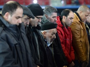 Paul Chiasson/THE CANADIAN PRESS
People pray Thursday at the funeral for three of the six victims of the Quebec City mosque shooting at the Maurice Richard Arena in Montreal.