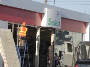 Construction workers work board up the storefront of the Shell Gas Station on Kepler Street. Two masked suspected rammed into the store on Feb. 1 in an effort to steal from an ATM inside, according to Whitecourt RCMP (Joseph Quigley | Whitecourt Star).