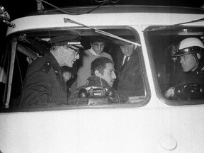Jack Weinberg (seated, left window), a long-time leader of demonstrations on the Berkeley campus and spokesmen for the Vietnam protest marchers, confers in a police van with officers in charge of the Oakland police detail assigned to stop marchers who did not have an Oakland marching permit in Berkeley, Calif., on Oct. 16, 1965. (AP/FILE)