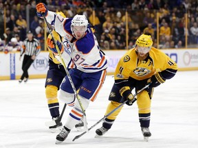 Edmonton Oilers center Connor McDavid (97) is defended by Nashville Predators' Ryan Ellis (4) during the first period of an NHL hockey game Thursday, Feb. 2, 2017, in Nashville, Tenn.